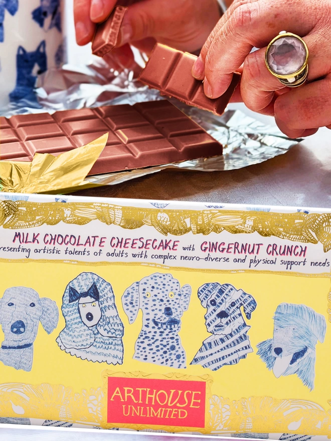 Milk chocolate with cheesecake gingernut crunch wrapped in foiled cardboard & drawn blue dog faces