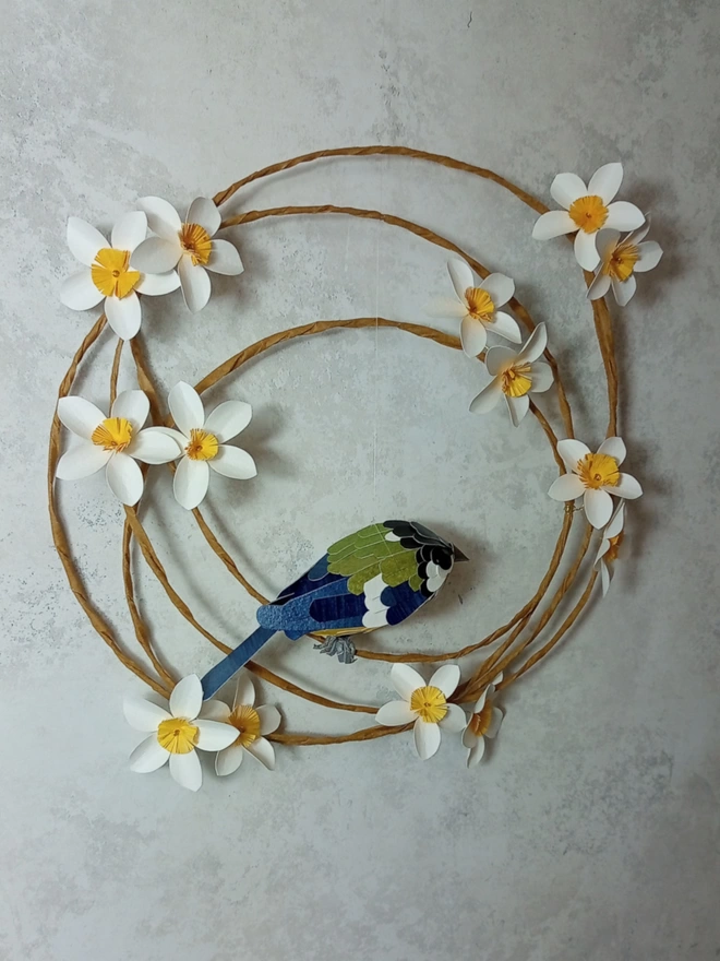 great tit on a wreath of white and yellow blossoms