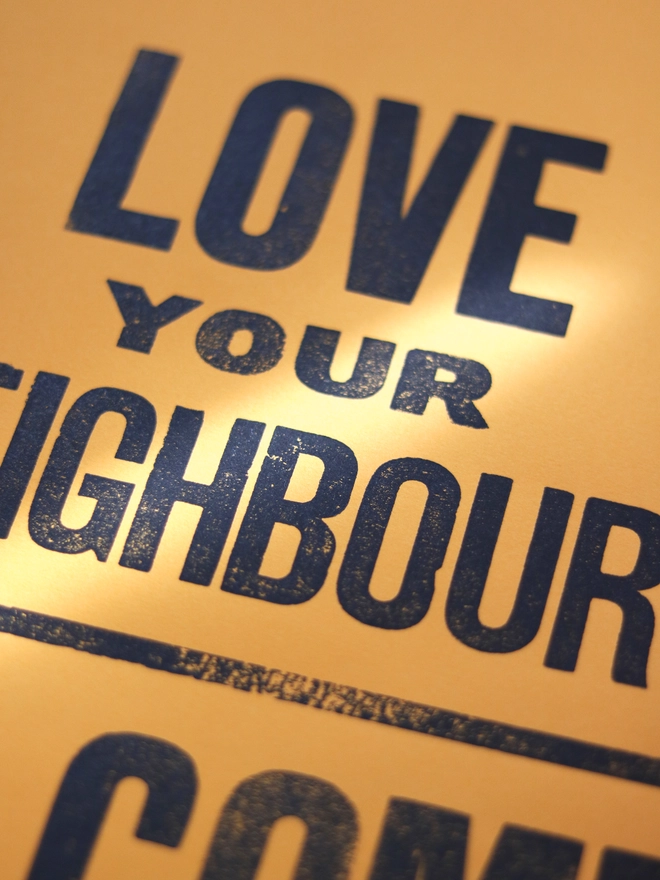 Original letterpress poster featuring the words 'love your neighbour, welcome the stranger'
