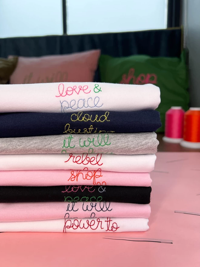 Colourful pile of embroidered t-shirts