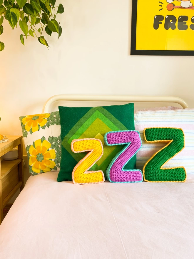 Crochet Cushions shaped like Z's on a bed
