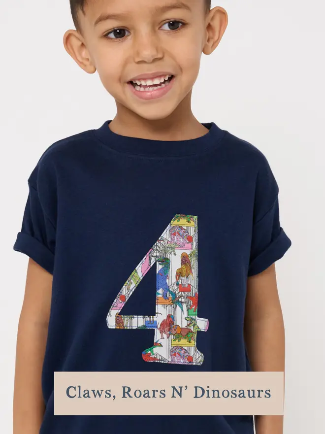 A navy birthday t-shirt with a number 4 cut from liberty dinosaur print on the front
