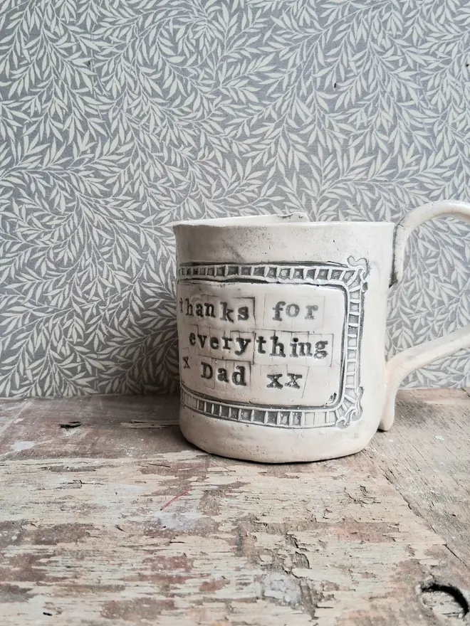 personalised message ceramic mug. a ceramic mug engraved with a personalised linocut message on the front, reading 'thanks for everything dad'.