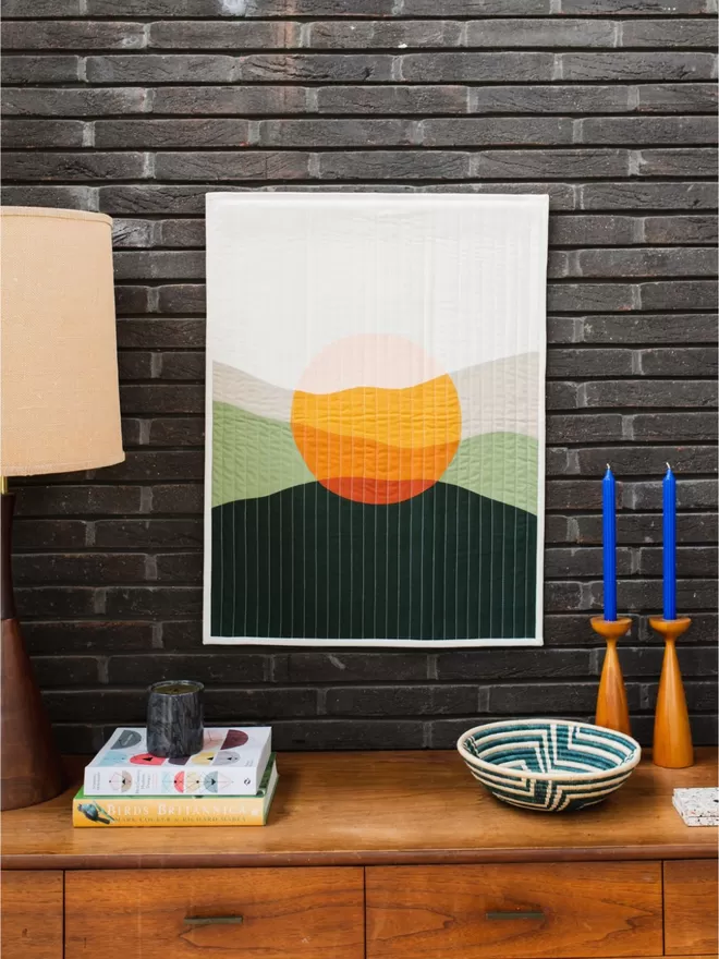 Westward Quilt Hanging On Wall Above Wooden Furniture