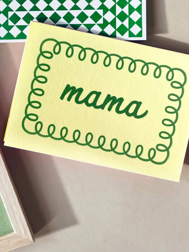 'Mama' yellow hand printed card on a table. 