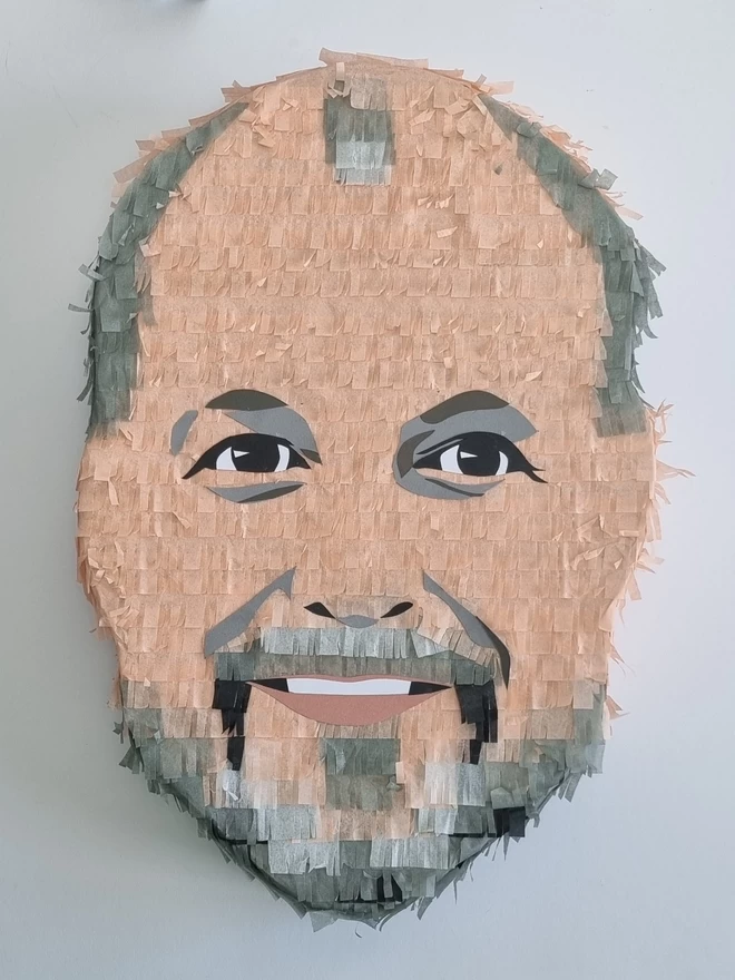 portrait pinata of a man with a grey beard and twinkly eyes