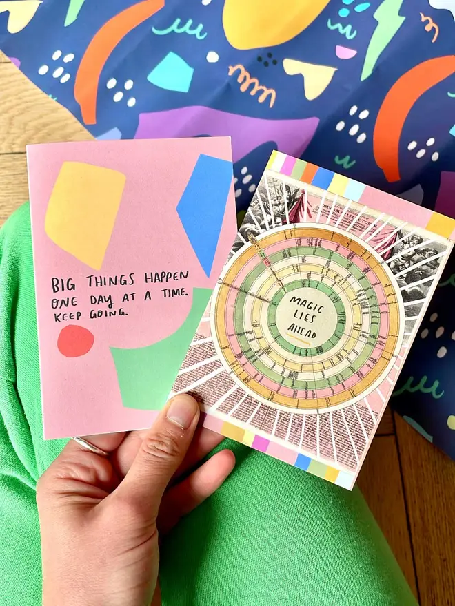 NIcola holds two brightly coloured greeting cards