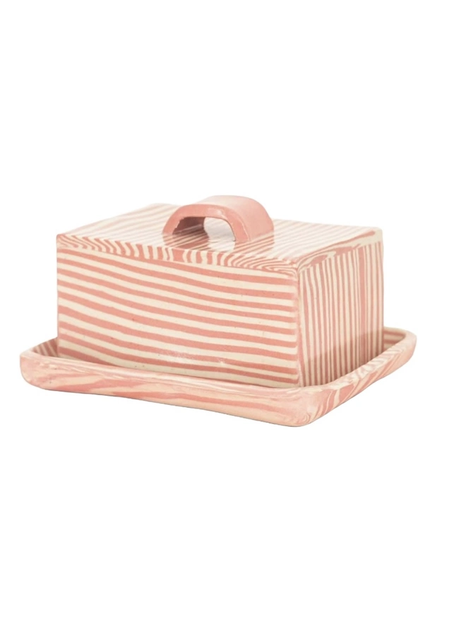 Striped Butter Dish, a colourful striped butter dish sitting on a white surface against a plain backdrop. 