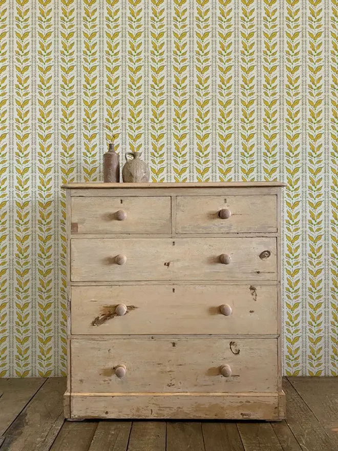 leaf stripe illustrated wallpaper. a yellow leaf patterned wallpaper on a wall.