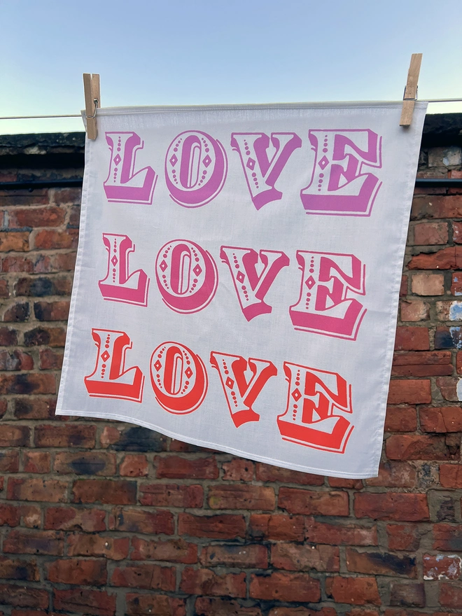 A Mr.PS Love Love Love Handkerchief hanging outside on a washing line