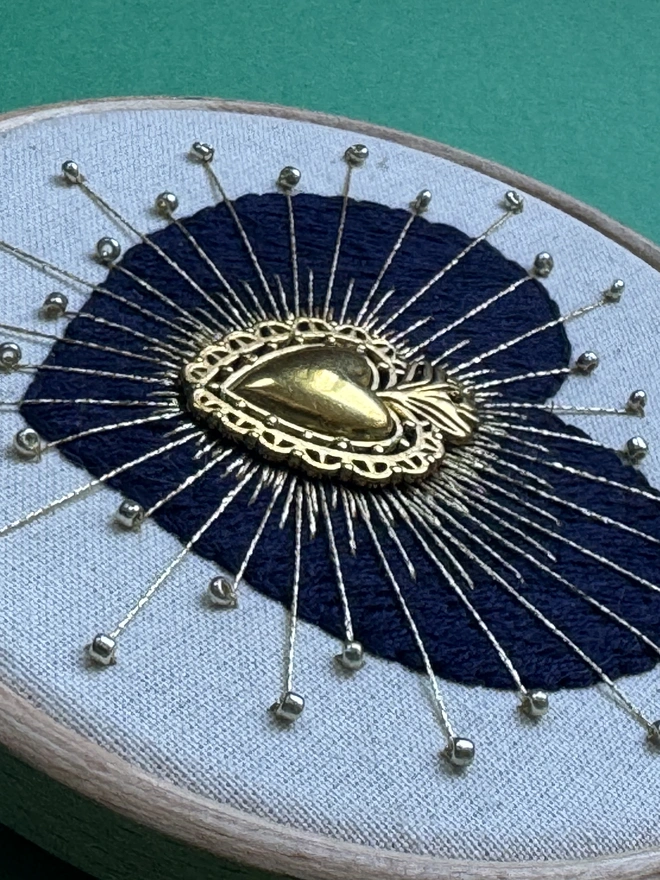Hand stitched navy embroidery heart in hoop, gold floss and beads