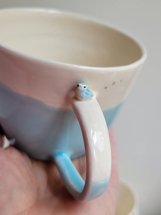 ceramic blue mug with tiny blue tit song bird on the handle and birdprints