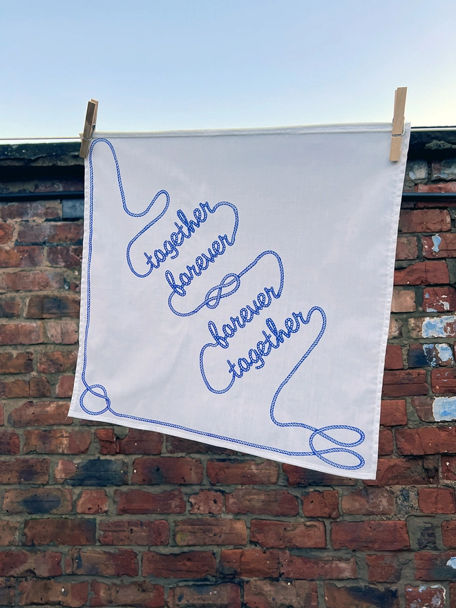 A Mr.PS Together Forever Handkerchief hanging outside on a washing line