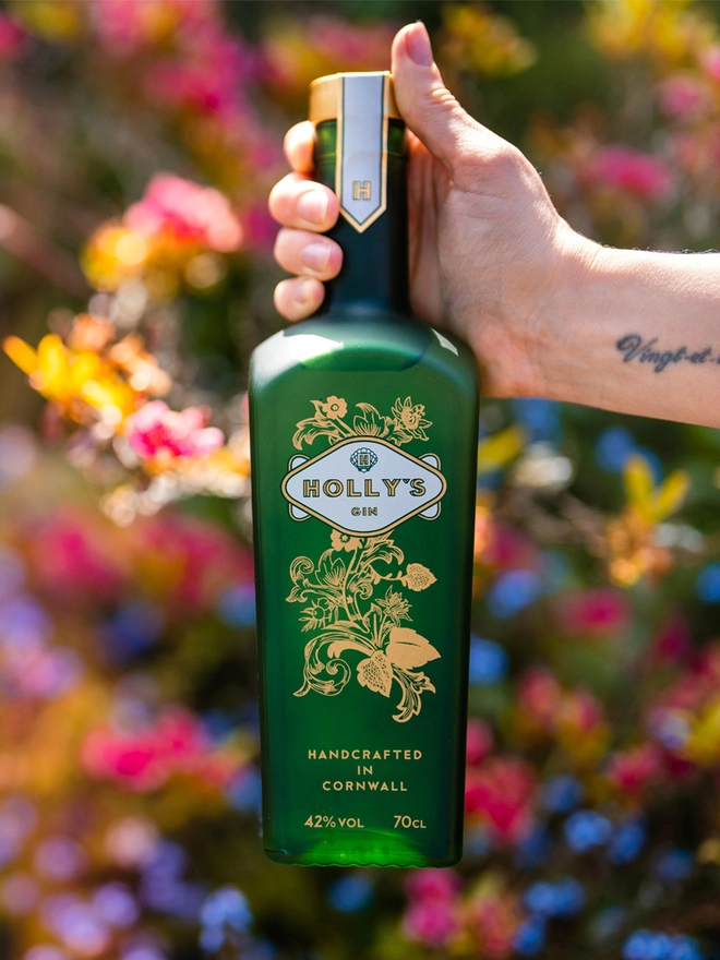 Holly's Gin bottle in front of colourful flowers