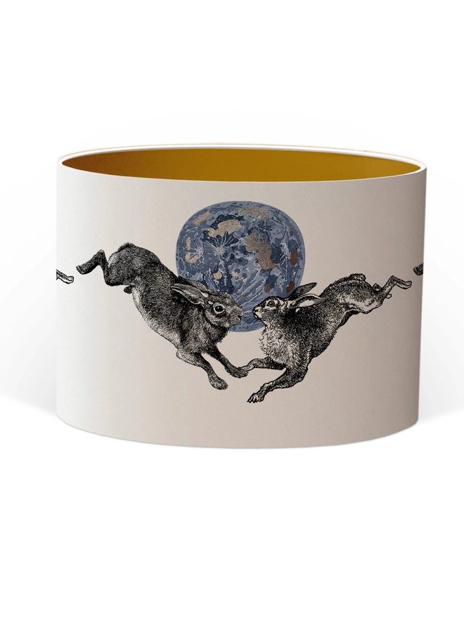 Drum Lampshade featuring a pair of hares leaping across a blue and silver moon with a Gold inner on a white background