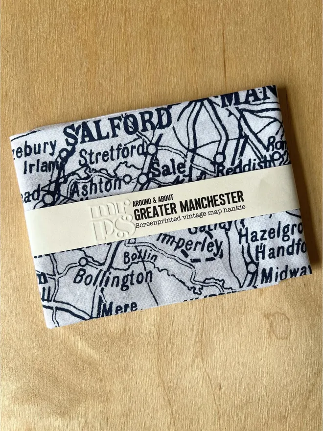 Folded Mr.PS Greater Manchester Handkerchief on a wooden table