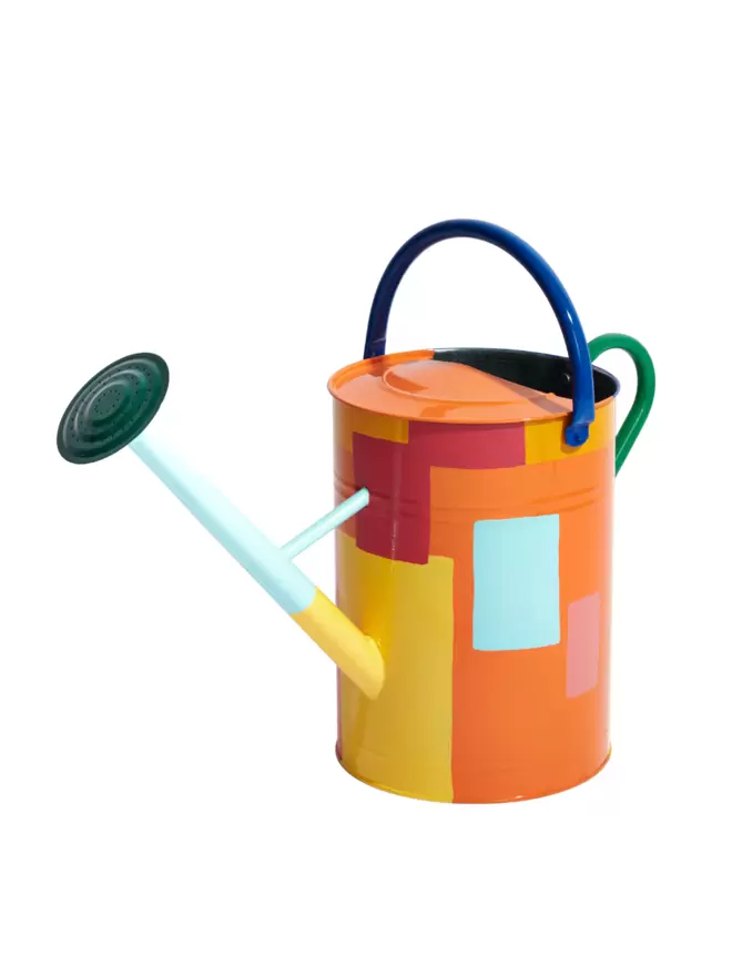 Orange, yellow and light blue patch work style painted watering can. Nozzle is dark green, handles are royal blue. Photographed from the front.