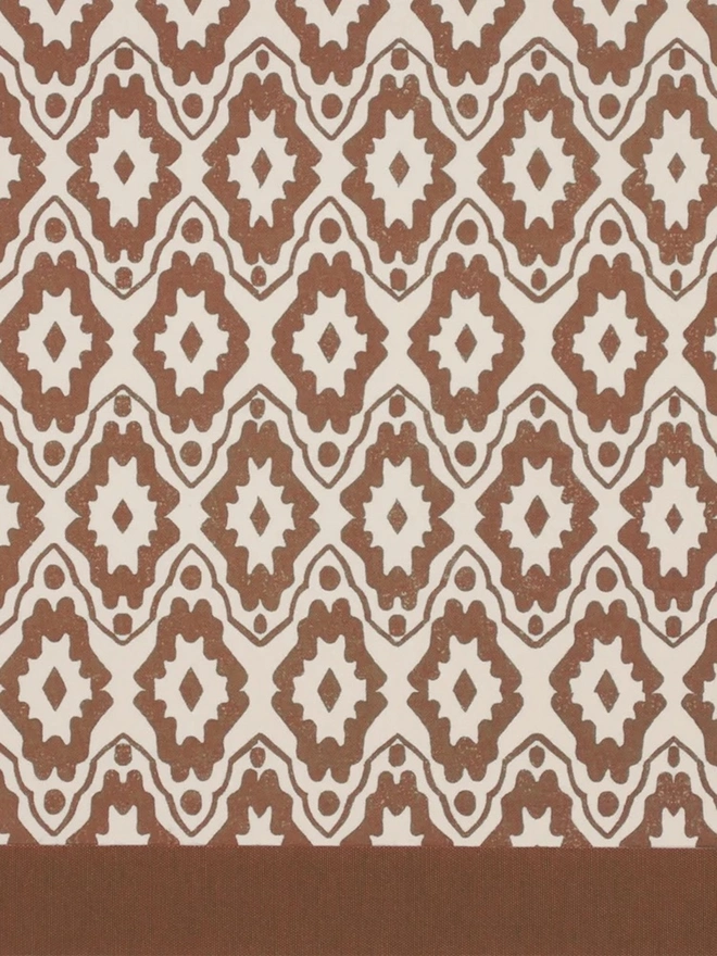 Paper Empire Lampshade. Close-up of a hand block printed lampshade showing a bold repeating geometric pattern. The colourful printed design and neat trim bring character and a handcrafted finish to any lamp.
