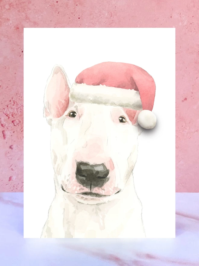 A Christmas card featuring a hand painted design of an english bull terrier, stood upright on a marble surface. 