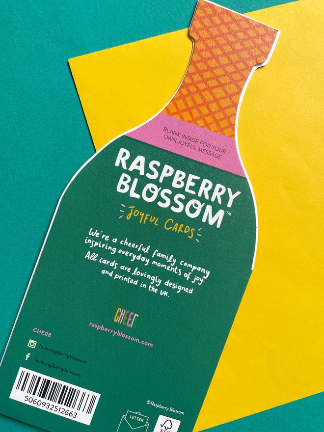 The reverse of the die cut champagne shaped birthday card has a small blurb about Raspberry Blossom, a cheerful family company inspiring everyday moments of joy