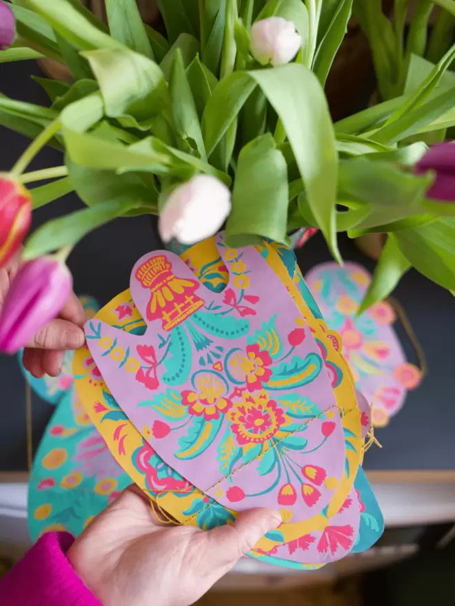 Lilac shapes held in front of white tulip flowers