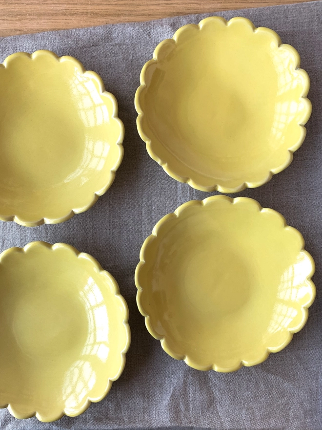 four yellow ice cream bowls with scallop edges