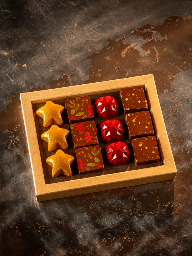 Christmas chocolate box containing 4 kinds of colourful bonbons - including yellow stars, gingerbread