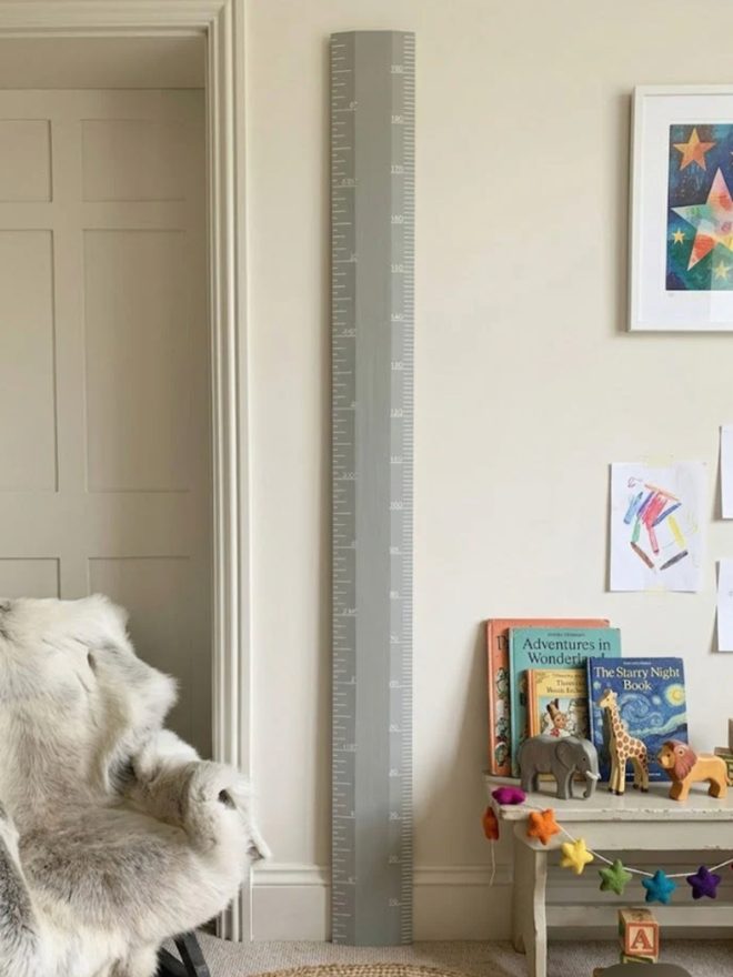 Wooden Height Chart. A large ruler height chart in Manor House Grey leaning against a child’s wall.