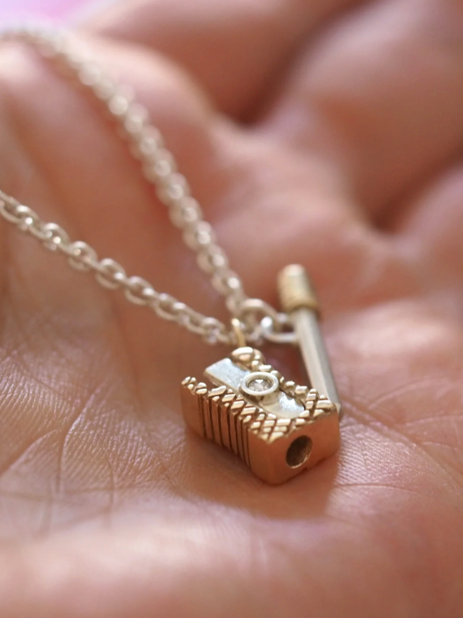Pencil & Sharpener Necklace. A gold pencil and sharpener necklace.