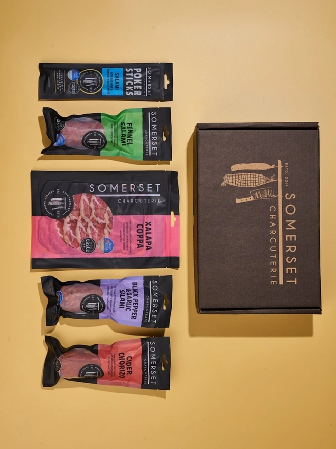 Branded gift box, presented with branded tissue paper containing a selection of charcuterie.