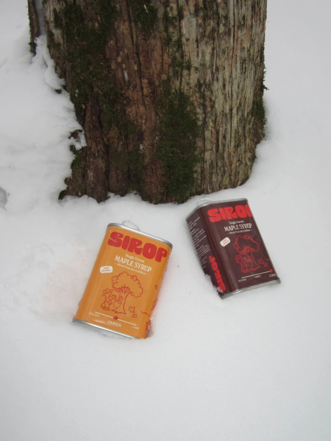 Maple Syrup Duo. Two cans of maple syrup from Sirop in the snow.