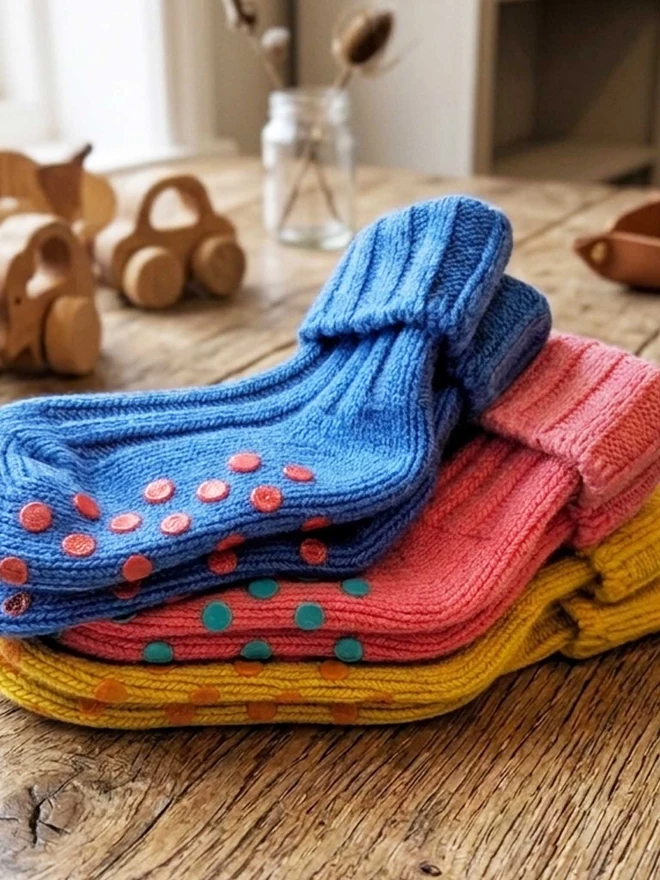 Pile Of Colourful Kids Socks Displayed On A Wooden Table