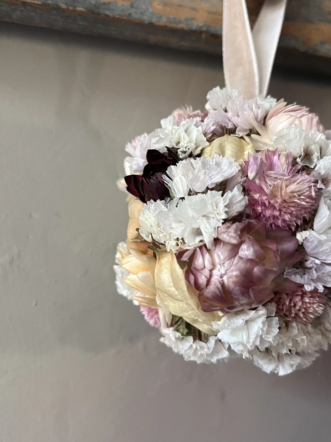 Pink and white dried flower bauble made using a selection of seasonal blooms. 