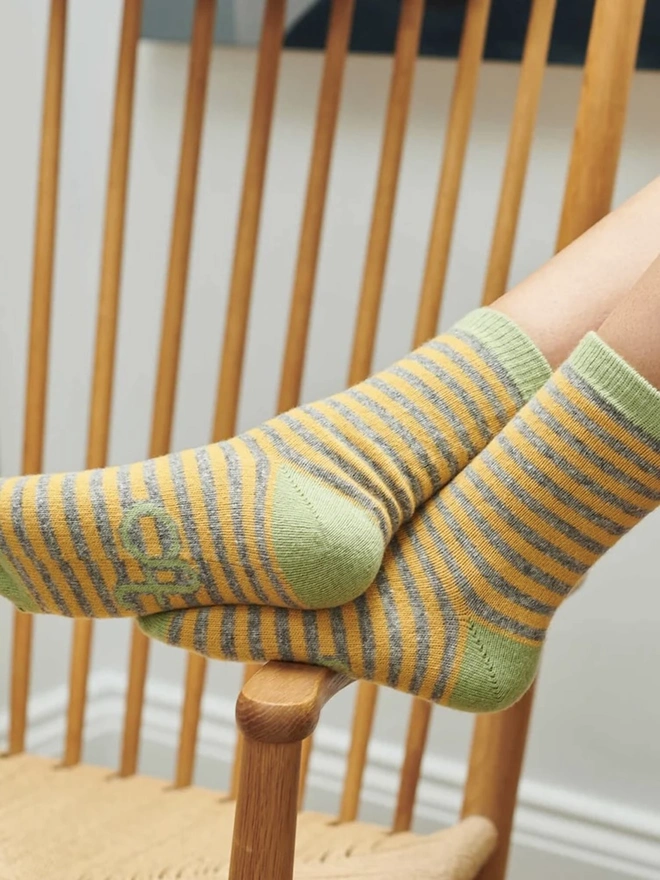 Women's Organic Cotten Striped Ankle Socks, a woman resting her feet, wearing a pair of striped ankle socks. 