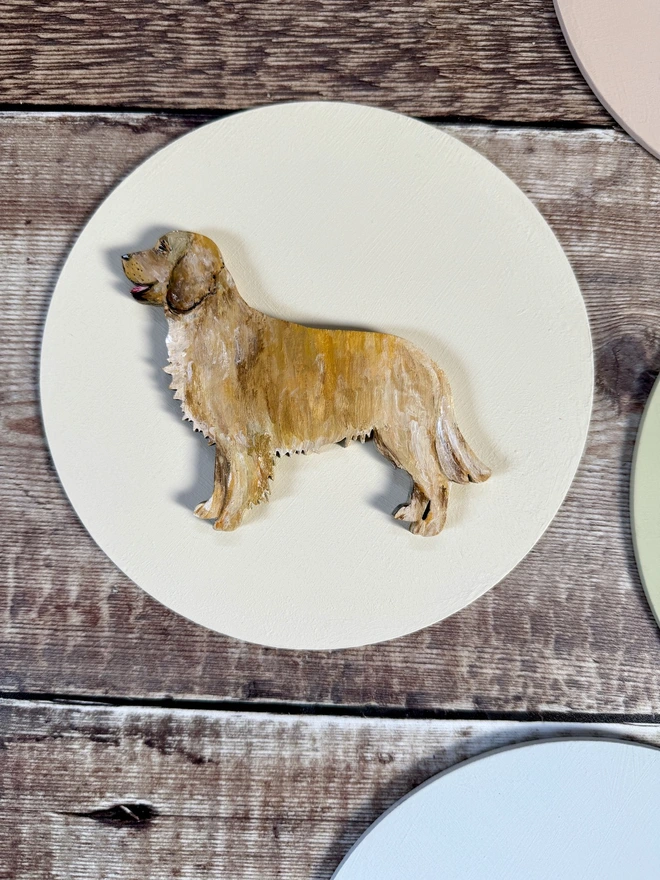 Hand Painted Golden Retriever dog Portrait mounted onto a circular wooden background also handpainted in pale pink 