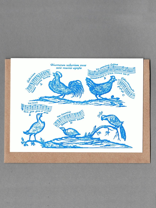 White card with blue birds and musical notes with a brown envelope behind