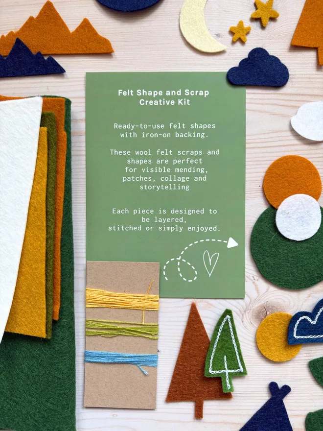 Felt shapes and scraps laid out with an instruction card on a wooden background