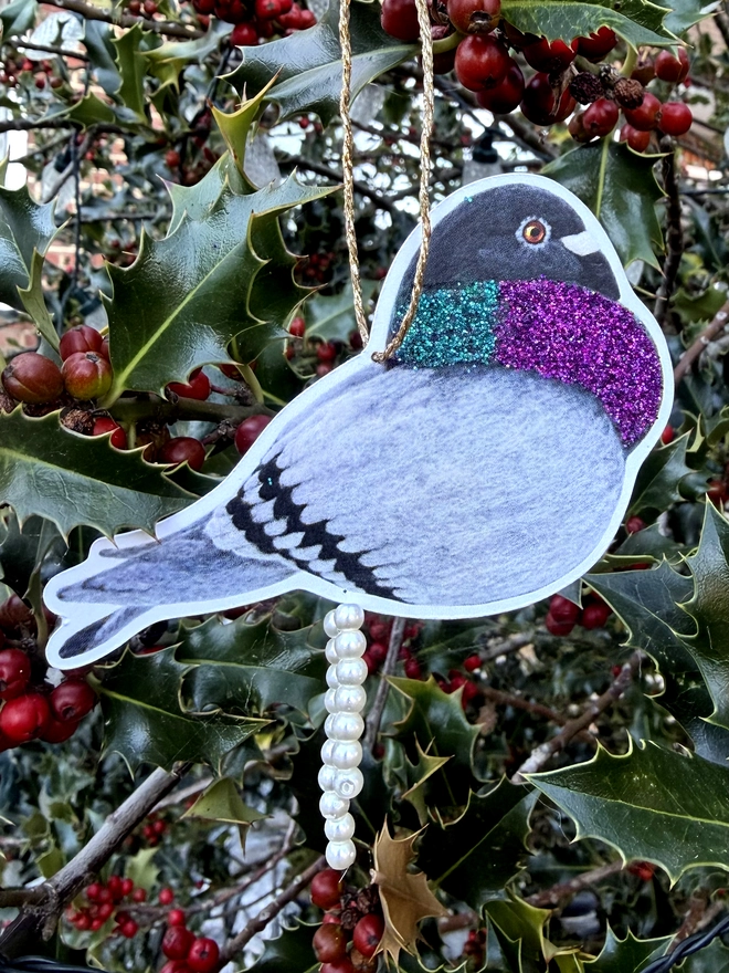 Pooping pigeon decoration with faux pearls and eco glitter hung on a holly tree