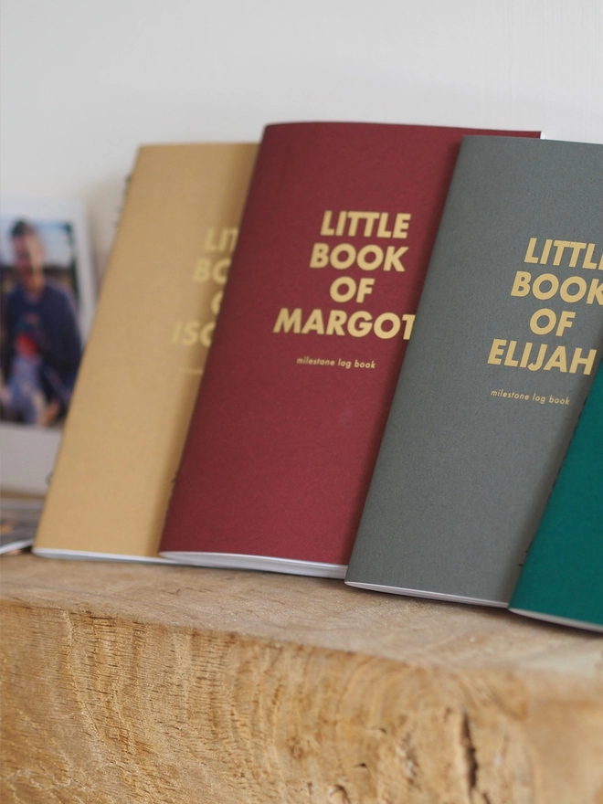 Three little pocket notebooks in different colours personalised with a name of a child in gold foil