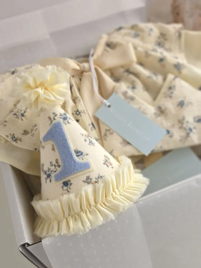Heirloom-inspired Mabel birthday collection presented in a gift box featuring a floral party hat, cape and matching crown.