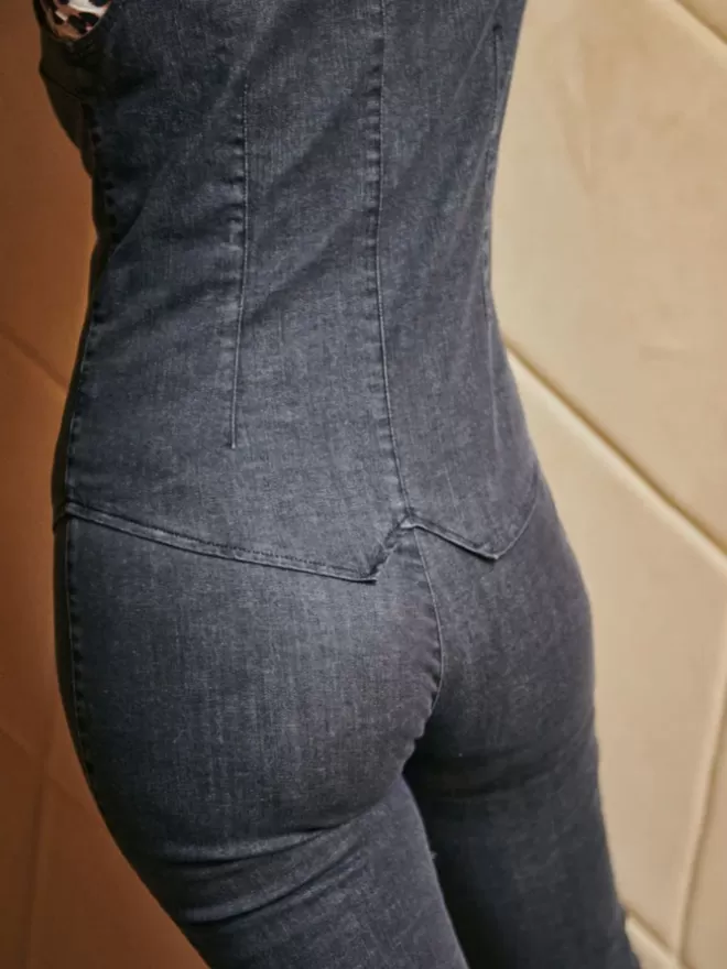 The NEW Jessie in washed balck denim worn by the model view of the back against beige backdrop