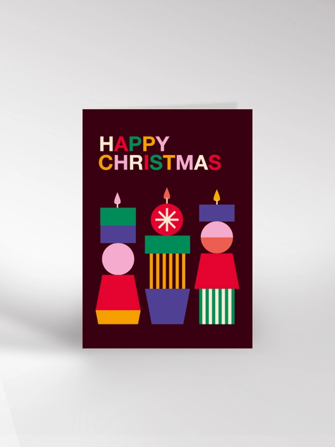 Contemporary illustrated Christmas card of three modern candles in rich, bright colours and saying 'Happy Christmas'