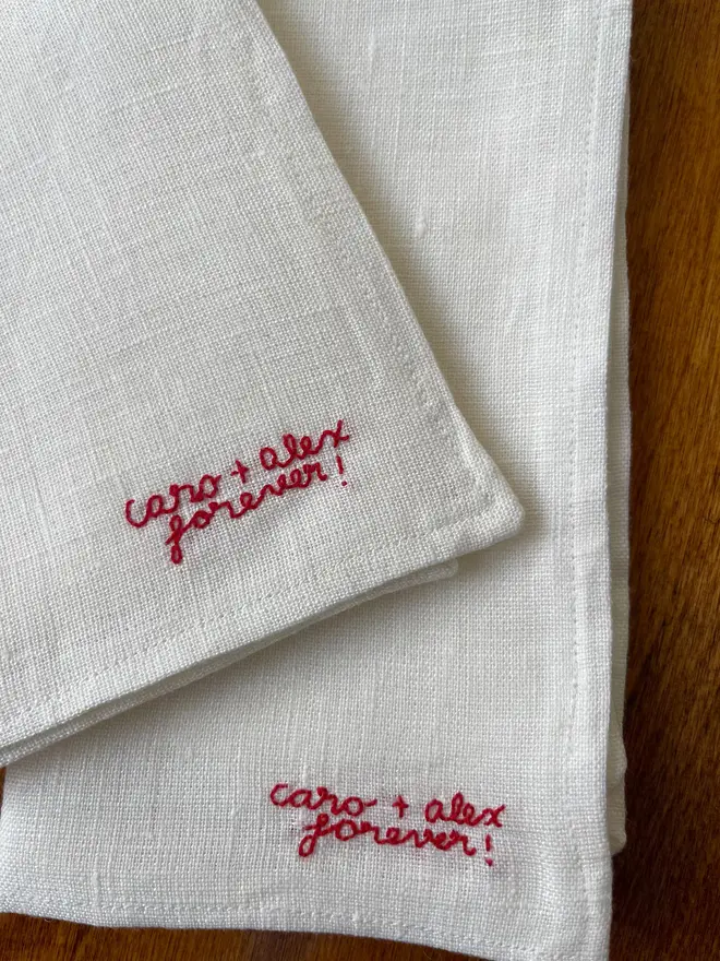 Personalised Hand Embroidered Linen Napkins (Set Of 2), two white napkins with a red personalised message