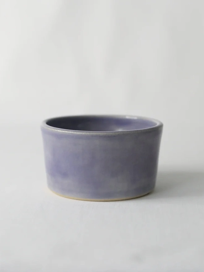 Classic Side Bowl, a colourful ceramic bowl on a wooden surface against a grey backdrop. 