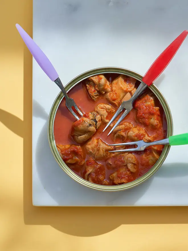 An open tin of Sea Sisters Norfolk Whelks In Kimchi Sauce with three forks placed inside