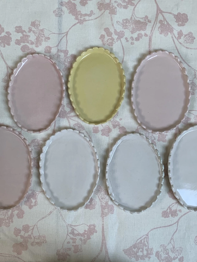 a group of butter dishes in white, blossom pink and butter yellow
