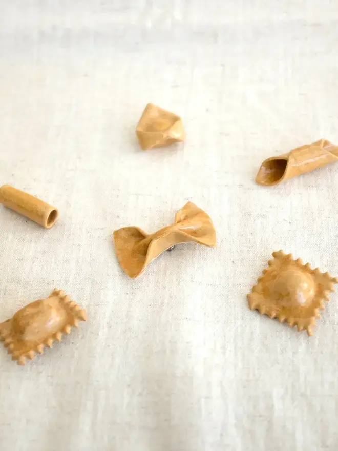 ceramic pasta magnets (set of 6). 6 pasta magnets in plain glaze photographed on a cloth.