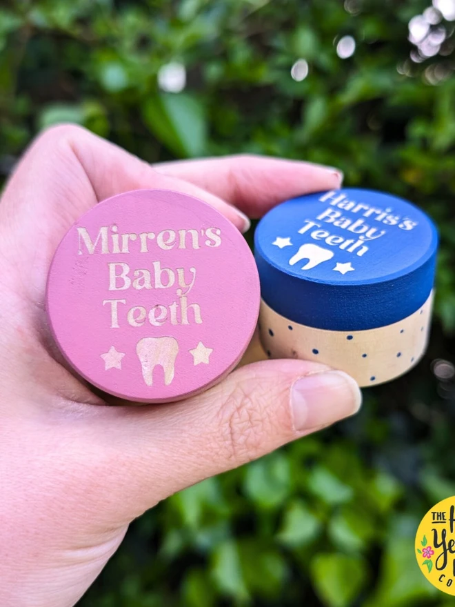 personalised wooden tooth fairy box. two round wooden boxes with pink and blue painted lids and personalised text.