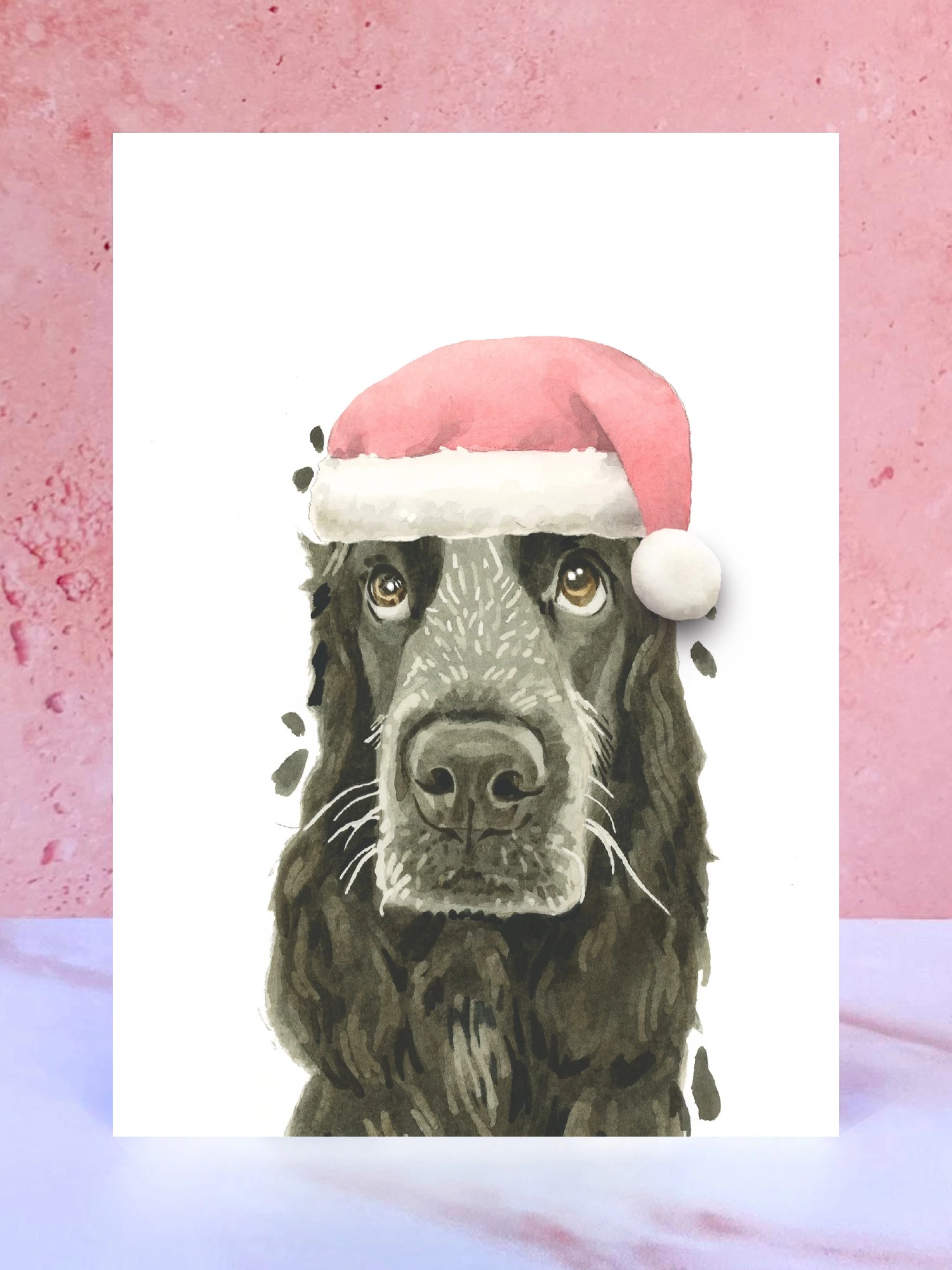 A Christmas card featuring a hand painted design of a cocker spaniel, stood upright on a marble surface surrounded by pompoms. 