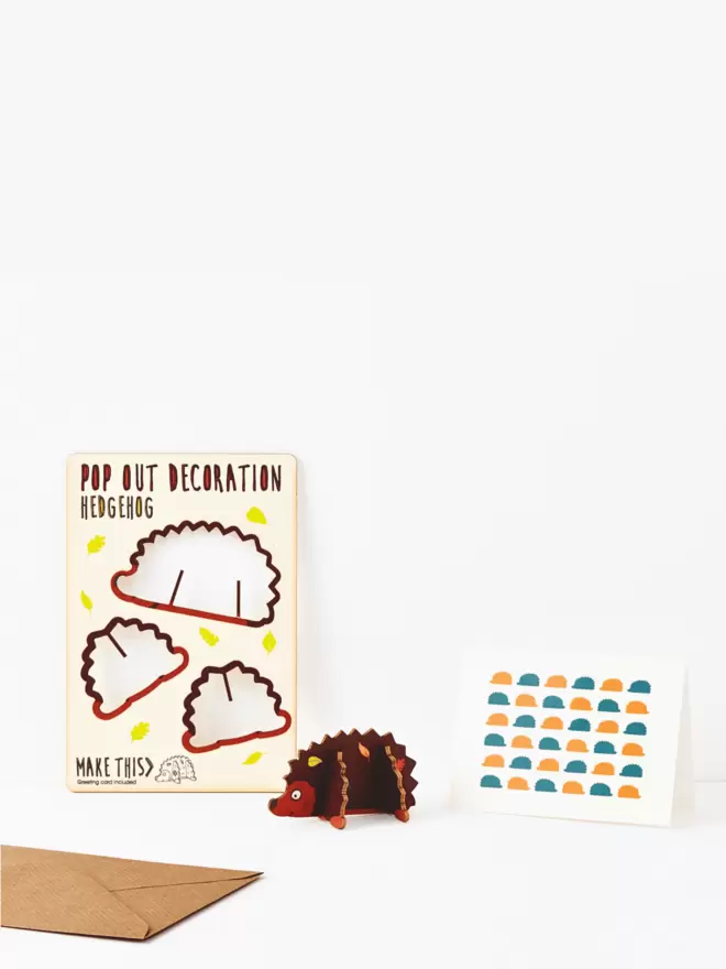 Hedgehog decoration and hedgehog pattern greeting card and brown kraft envelope on a white background